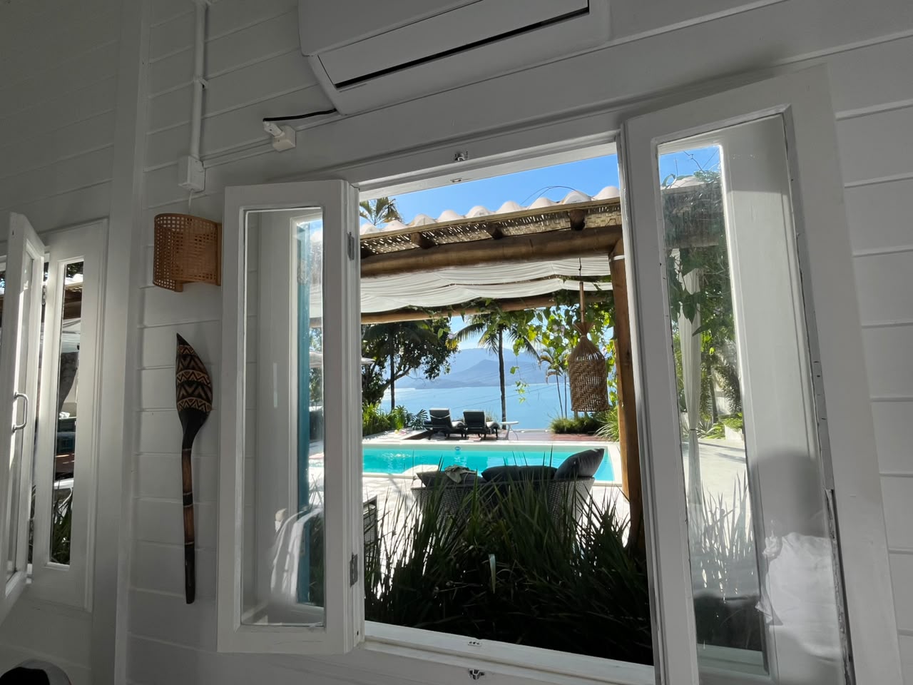Lounge à beira da piscina, casa com venezianas azuis