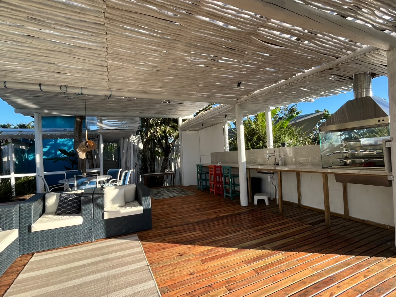 Detalhe da pérgola de fibra natural com a casa ao fundo