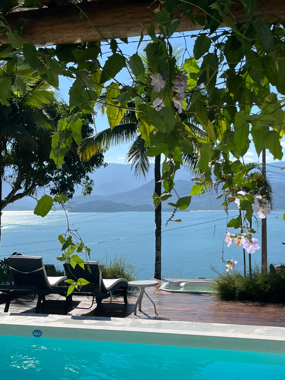 Vista ampla da piscina e hidro, montanhas e mar