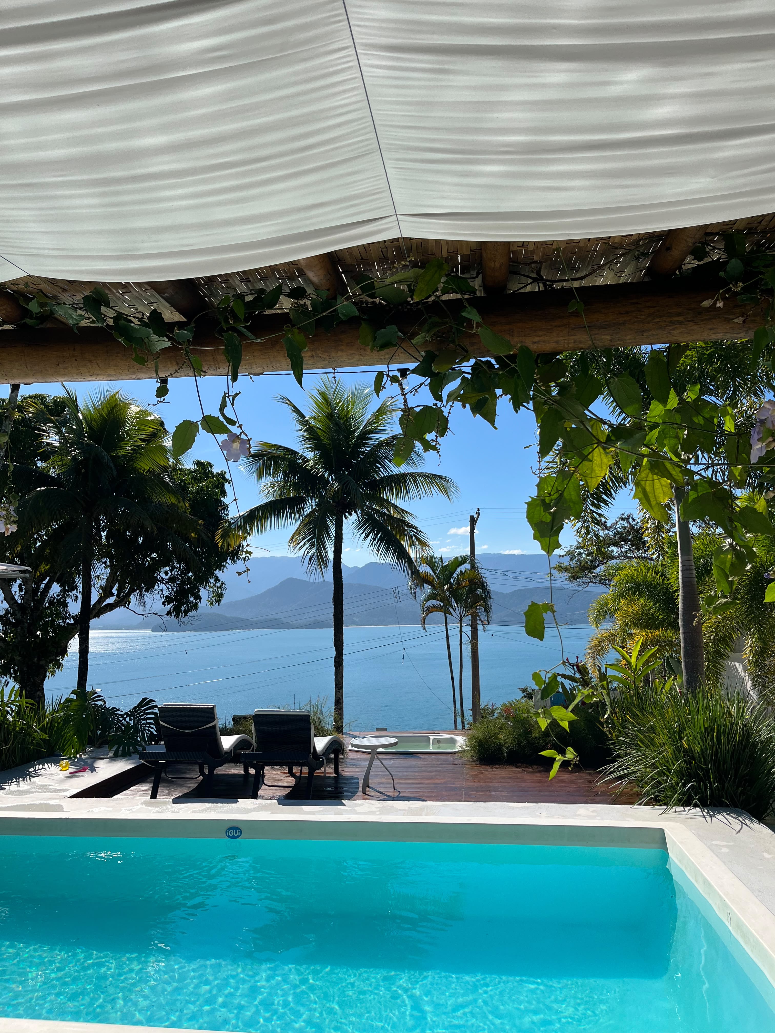 Piscina e hidro com espreguiçadeiras, vista para a baía