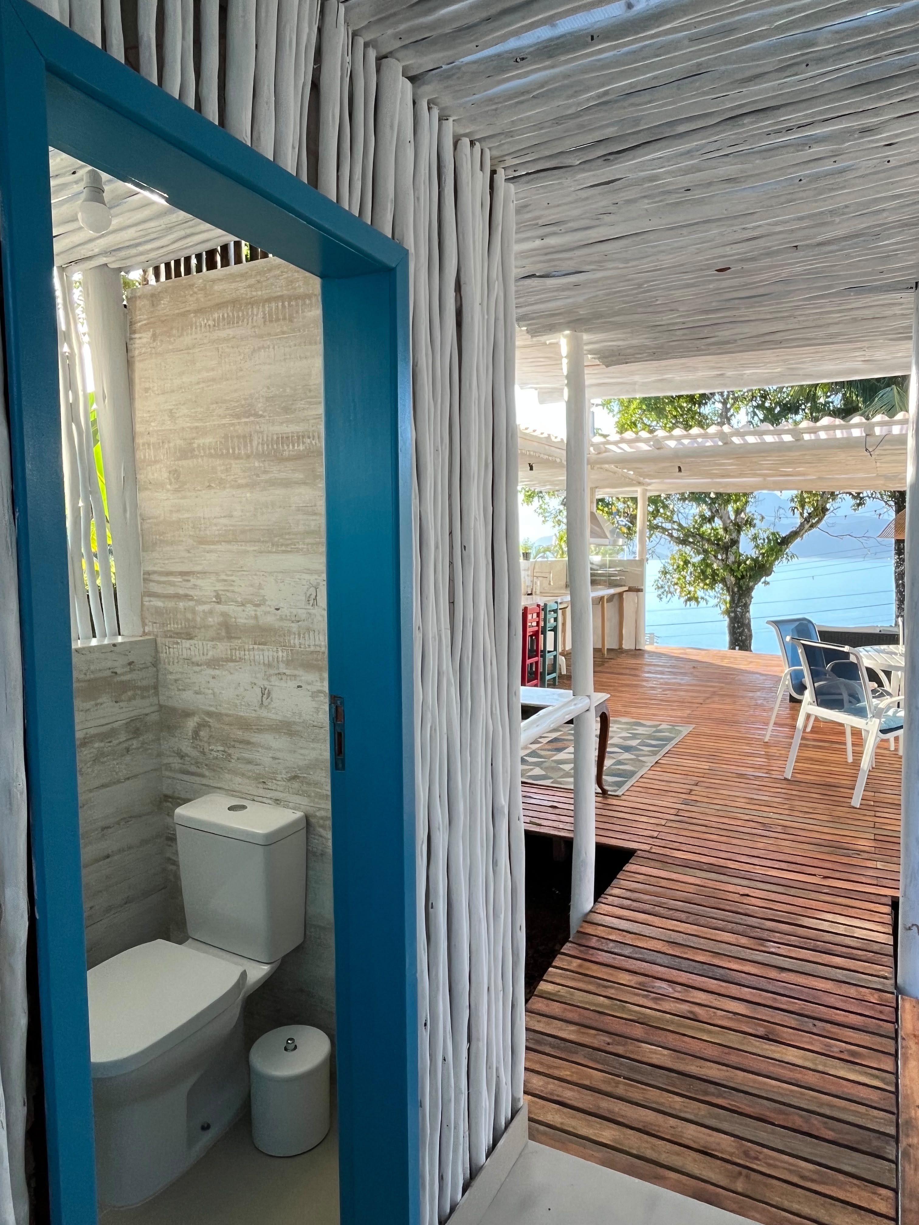 Banheiro externo com acesso ao deck e vista para o mar